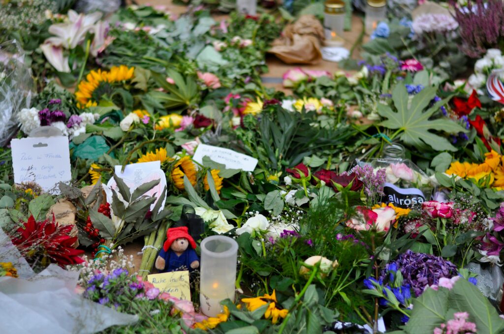 flowers, toys, and notes people left for a deceased to pay condolences